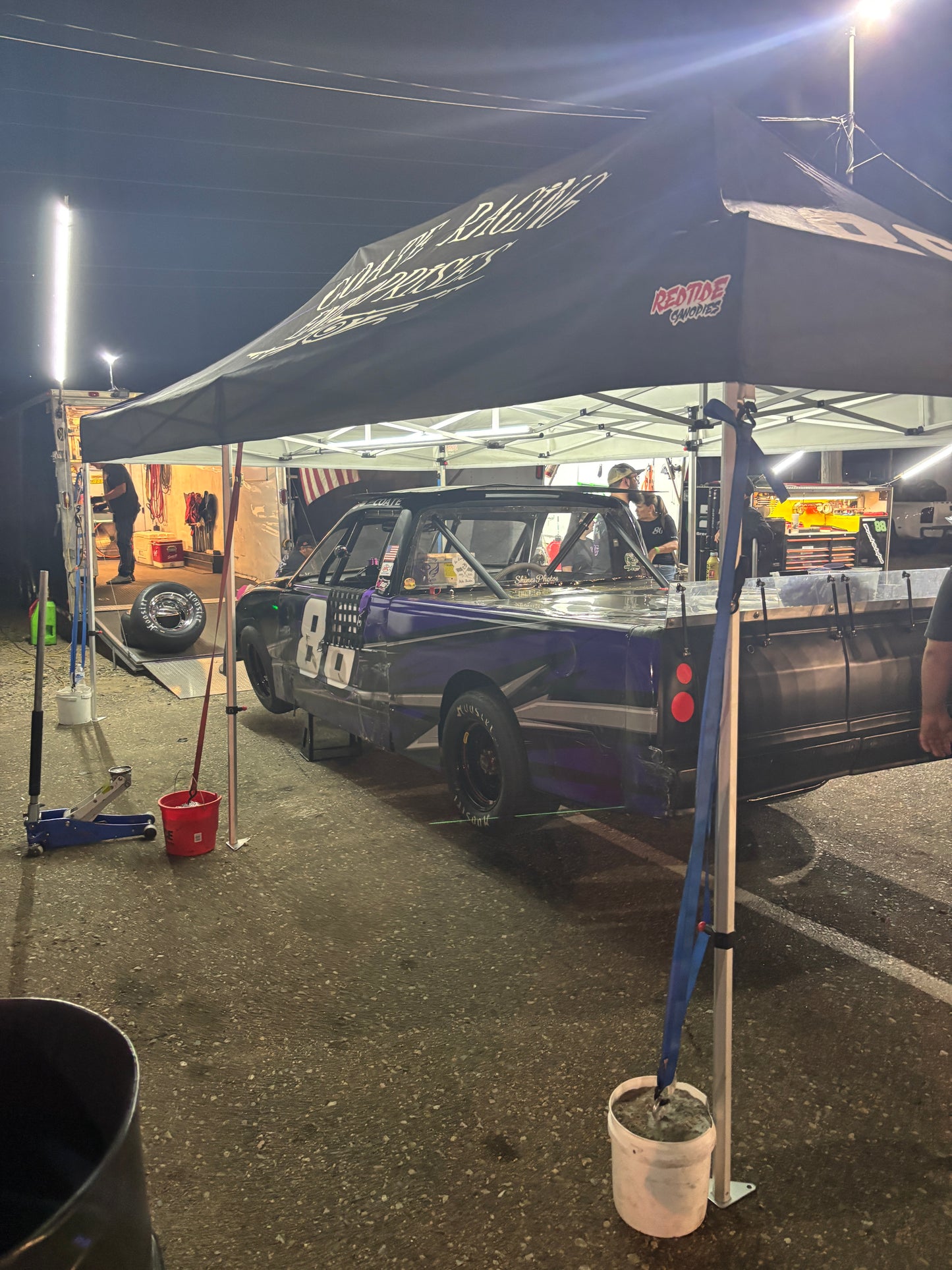 Car on a lift with a banner in the foreground at a garage or workshop. Illuminating Sponsors