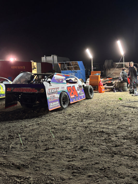 Dirt Modified on a dirt track at night with bright lights illuminating the scene.